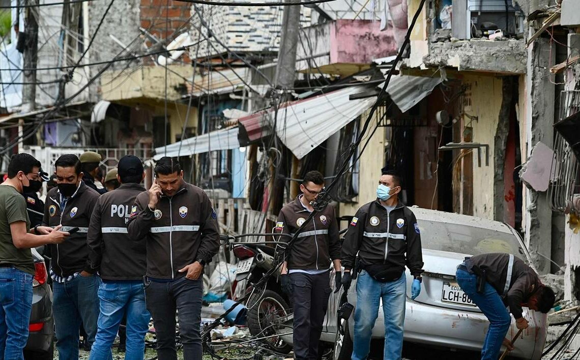 Members of the National Police inspect the site of an explosion, which the Ecuadorean government attributes to organized crime, in southern Guayaquil, Ecuador, on August 14, 2022. Five people died and another 16 were injured due to an explosion in Guayaquil, which the Ecuadorean government attributed to organized crime that is hitting the country, authorities and relief agencies reported. (Photo by Marcos PIN / AFP)